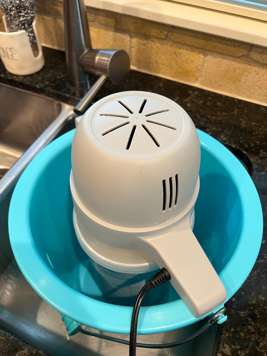 Put bucket containing ice cream mixture in sink and attach motor.